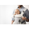 Fotografia, na której jest BABYBJORN - śliniaczek do nosidełka ergonomicznego BABYBJORN One, biały